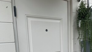 A white door with a keypad lock and a small window.
