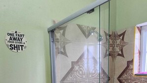 A bathroom with a toilet, a glass shower enclosure, and a wall with a star pattern.