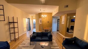 A modern living room with a sofa set, a coffee table, and a chandelier. - Modern 2-Bedroom Apartment with Private Pool and Balcony in Wilmington (Wilmington)