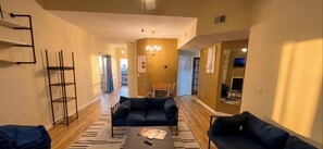A modern living room with a sofa set, a coffee table, and a chandelier. - Modern 2-Bedroom Apartment with Private Pool and Balcony in Wilmington (Wilmington)