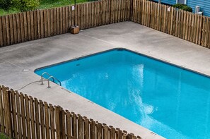 Una piscina rectangular rodeada por una valla de madera.