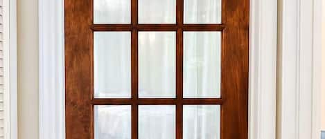 A wooden door with a grid pattern and frosted glass panels.