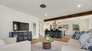 Ein modernes Wohnzimmer mit einer Couch, einem Couchtisch und einem Fernseher.