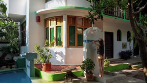 A pool area with a tiled deck, a small table, and potted plants. - Puerta Del Sol (Puerto Escondido)