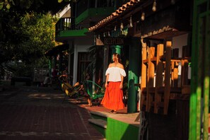 A building with a reception area, a green awning, and a staircase leading to the entrance. - Puerta Del Sol (Puerto Escondido)