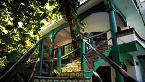 A staircase with green railings and patterned steps, leading to an upper level of a building. - Puerta Del Sol (Puerto Escondido)