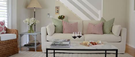 A living room with a sofa, a coffee table, a lamp, and a bookshelf.