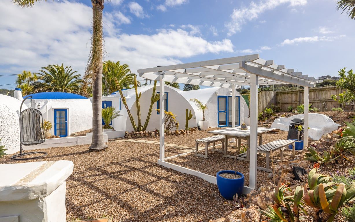 A patio with a pergola, outdoor seating, and cacti.