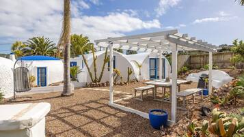A patio with a pergola, outdoor seating, and cacti.