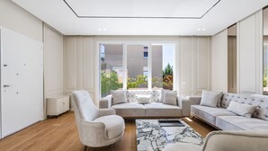Una sala de estar moderna con un sofá, sillones y una mesa de centro.