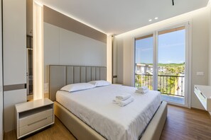 A modern bedroom with a large bed, a bedside table, a built-in wardrobe, and a balcony with a view. - White Escape 3BR Luxury Lalzi Beach Villa (Ishëm)