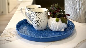 A kitchen area with a kettle, a blue tray, and a decorative plant. - Vancouver Katherine 2BD 2BA Laneway Home (Vancouver)