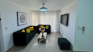 Ein modernes Wohnzimmer mit einer Couch, einem Couchtisch und einem Fernseher.