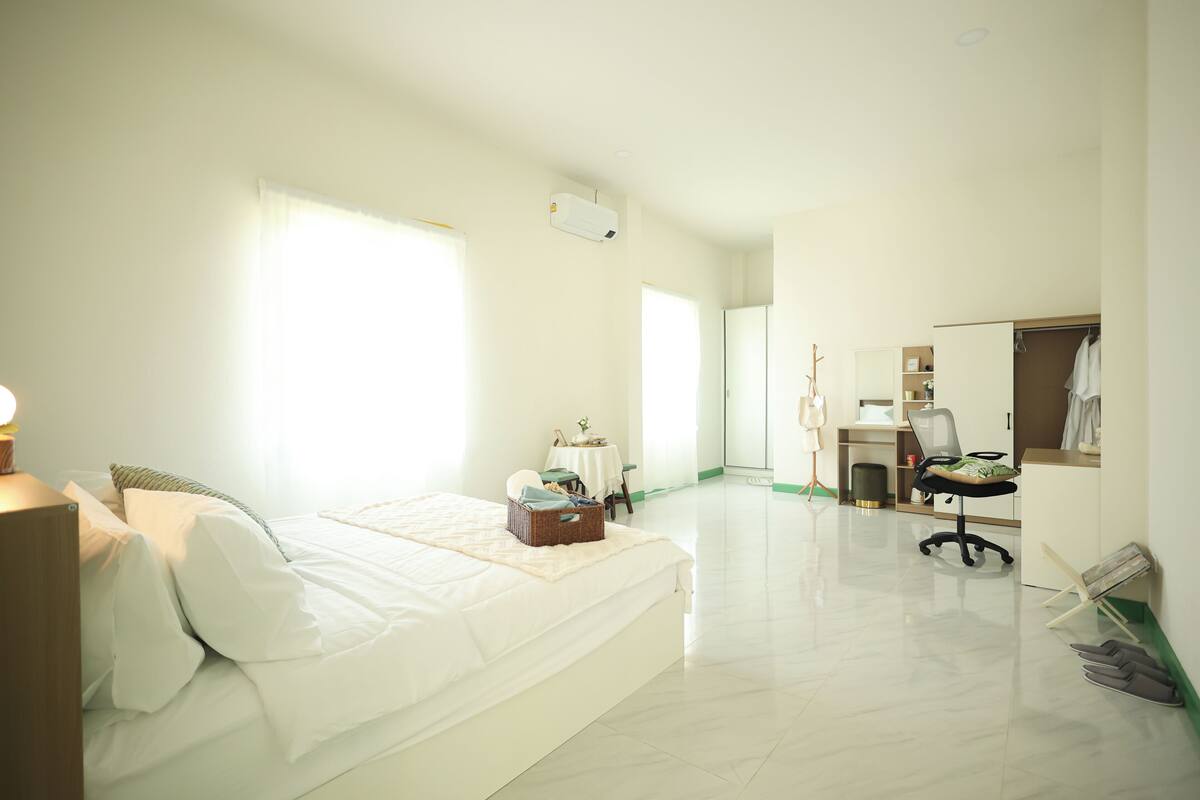 Une chambre d’hôtel comprenant un lit, un bureau, une chaise, un miroir et une armoire.