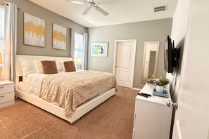 A bedroom with a bed, a desk, a ceiling fan, and artwork on the walls. - Sunset Swims Disney Dreams-modern Family Oasis (Davenport)