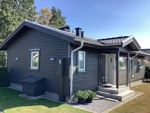 A modern two-story house with a dark siding exterior, a front porch, and a chimney. - 4 Star Holiday Home in Solvesborg (Sölvesborg)
