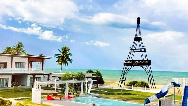 Un resort con piscina, zona de descanso y vistas al océano.