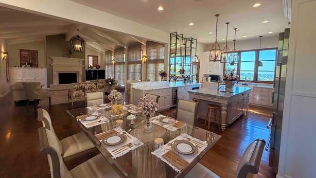A spacious kitchen with a large island, modern appliances, and a dining area set for a meal.