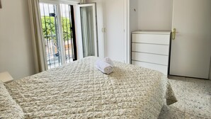 Un dormitorio con cama, armario y una pequeña alacena.
