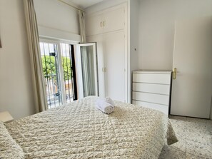 Ein Schlafzimmer mit einem Bett, einem Kleiderschrank und einem kleinen Schrank.