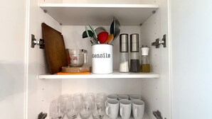 A kitchen cabinet with utensils, measuring cups, and storage containers. - Vancouver Lucy House (Vancouver)