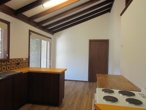 A kitchen with wooden cabinets, a stove, and a window with a view. - Barnard Beach House
Family home welcoming dogs. Walking distance to the beach. (Broadwater)
