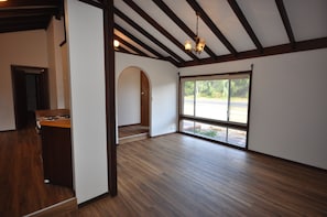 An empty room with a wooden floor, a large window, and a chandelier. - Barnard Beach House
Family home welcoming dogs. Walking distance to the beach. (Broadwater)