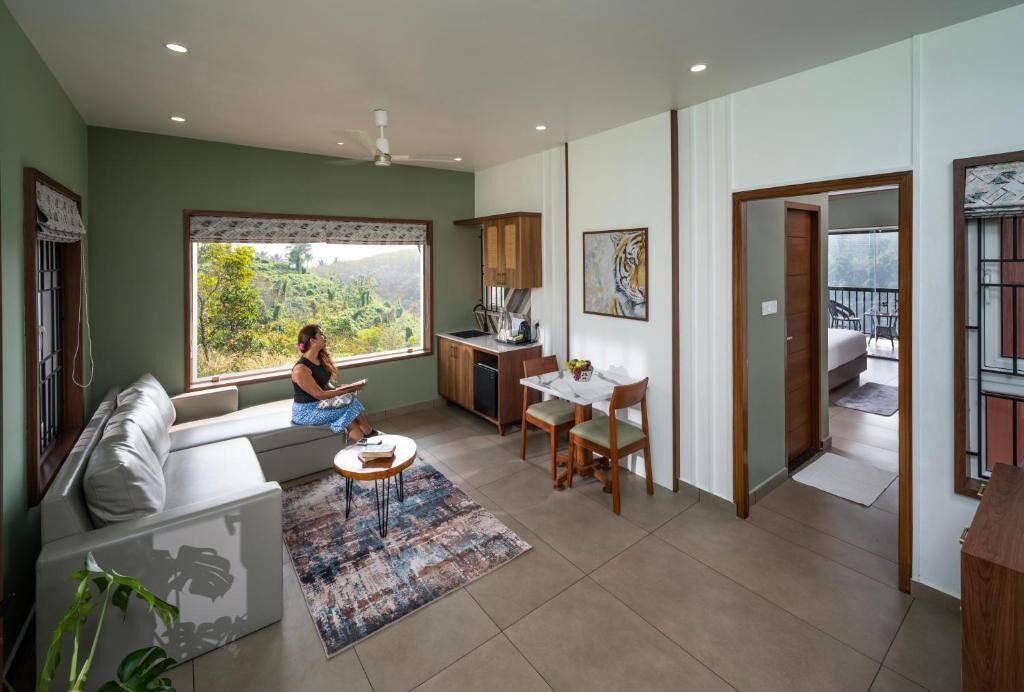 A living room with a sofa, a dining table, and a kitchen area.