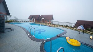A swimming pool with a lifeguard chair and a yellow inflatable ring.