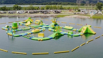 Um parque aquático com estruturas infláveis e um lago.