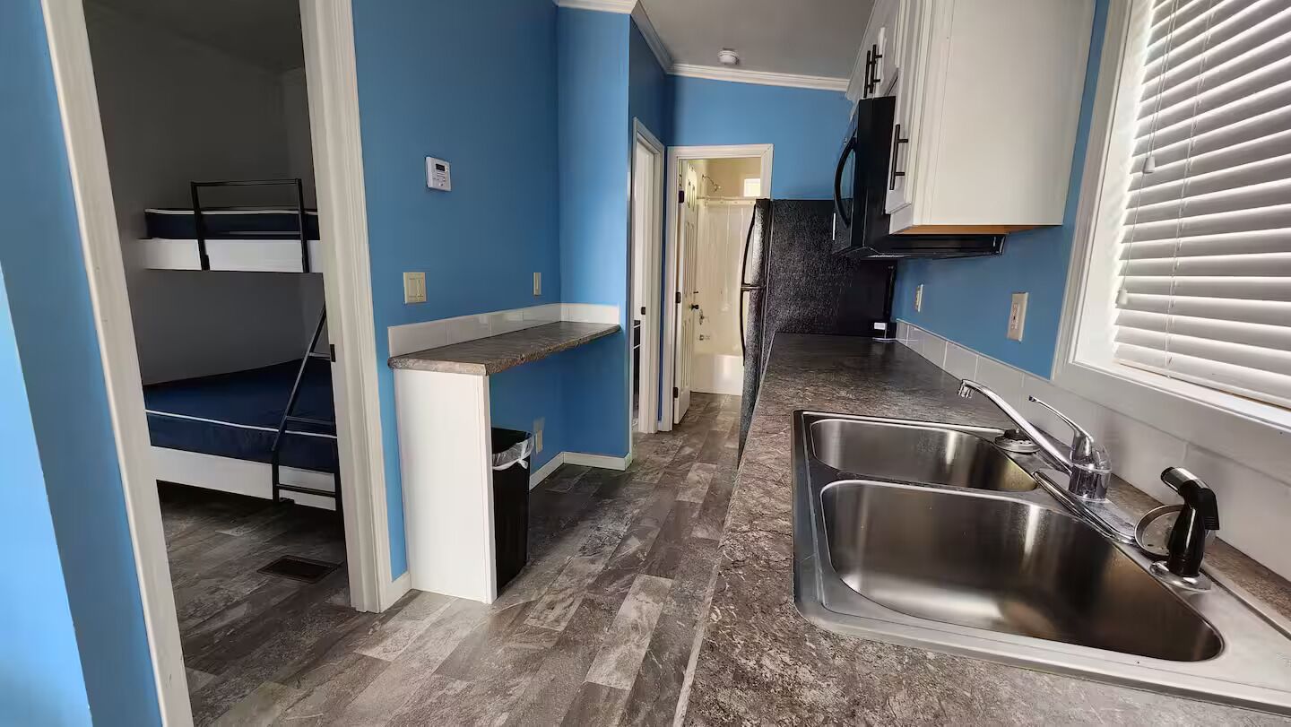 A compact kitchen with a built-in sink, a microwave, and a small countertop.