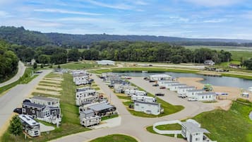 A campground with RVs and mobile homes, a lake, and a road curving through the area.
