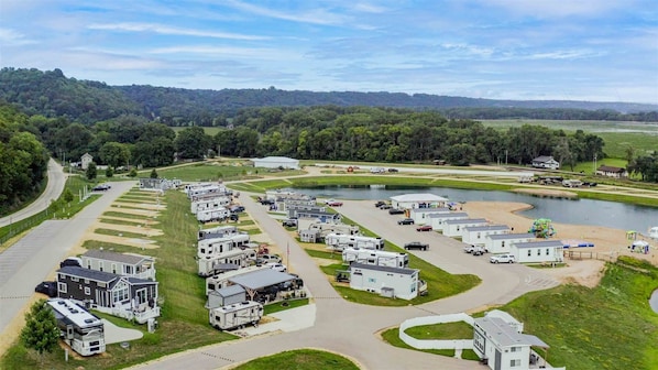 A campground with RVs and mobile homes, a lake, and a road curving through the area.
