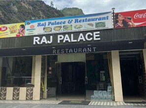 A restaurant named Raj Palace with a Coca-Cola advertisement above. - Raj Palace (Joshimath)