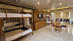 A room with bunk beds, a desk, chairs, a TV, and a bed. - Shagun Resort & Water Park (Igatpuri)
