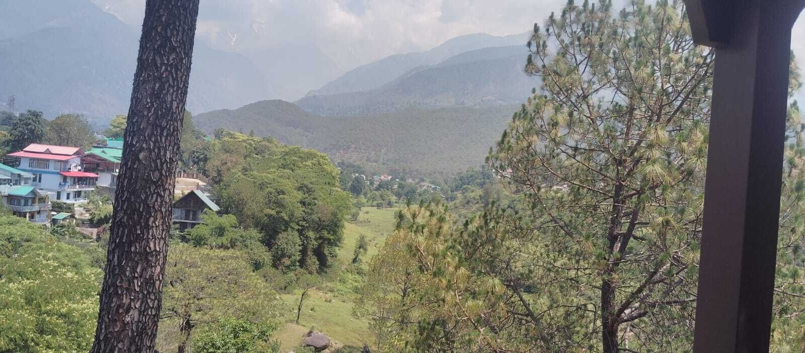 Paisaje montañoso con árboles y edificios en el valle.