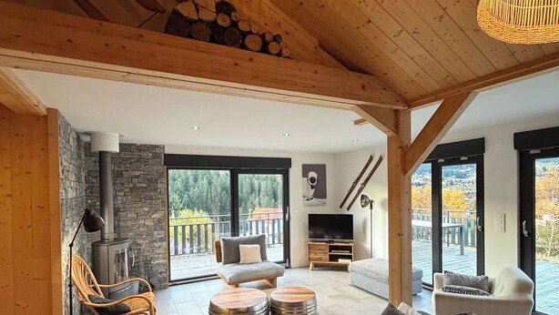 Ein modernes Wohnzimmer mit einer großen Couch, einem Kamin und einer Steinwand.