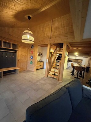 A spacious living area with a wooden ceiling, a staircase, a dining area, and a kitchen. - Chalet - Au Coeur des Vosges - Beds, towels and housekeeping included (Xonrupt-Longemer)
