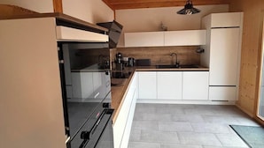 Eine moderne Küche mit Backofen, Spüle und Kühlschrank.