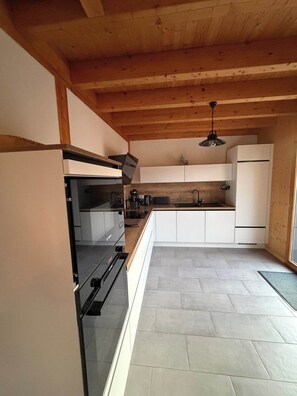 A modern kitchen with a built-in oven, a sink, and a refrigerator. - Chalet - Au Coeur des Vosges - Beds, towels and housekeeping included (Xonrupt-Longemer)