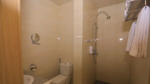 Une salle de bain équipée d’un lavabo, de toilettes, d’un miroir et d’une douche.