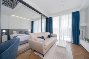 Ein modernes Hotelzimmer mit Bett, Sofa und einem kleinen Tisch.