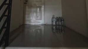A narrow hallway with a closed door, a staircase on the left, and a water dispenser on the right. - Room-cozy Old Town Room 5 min Walk Local (Phuket)