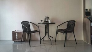 A small room with a round table, two chairs, a coffee maker, and a wooden cabinet. - Room-cozy Old Town Room 5 min Walk Local (Phuket)
