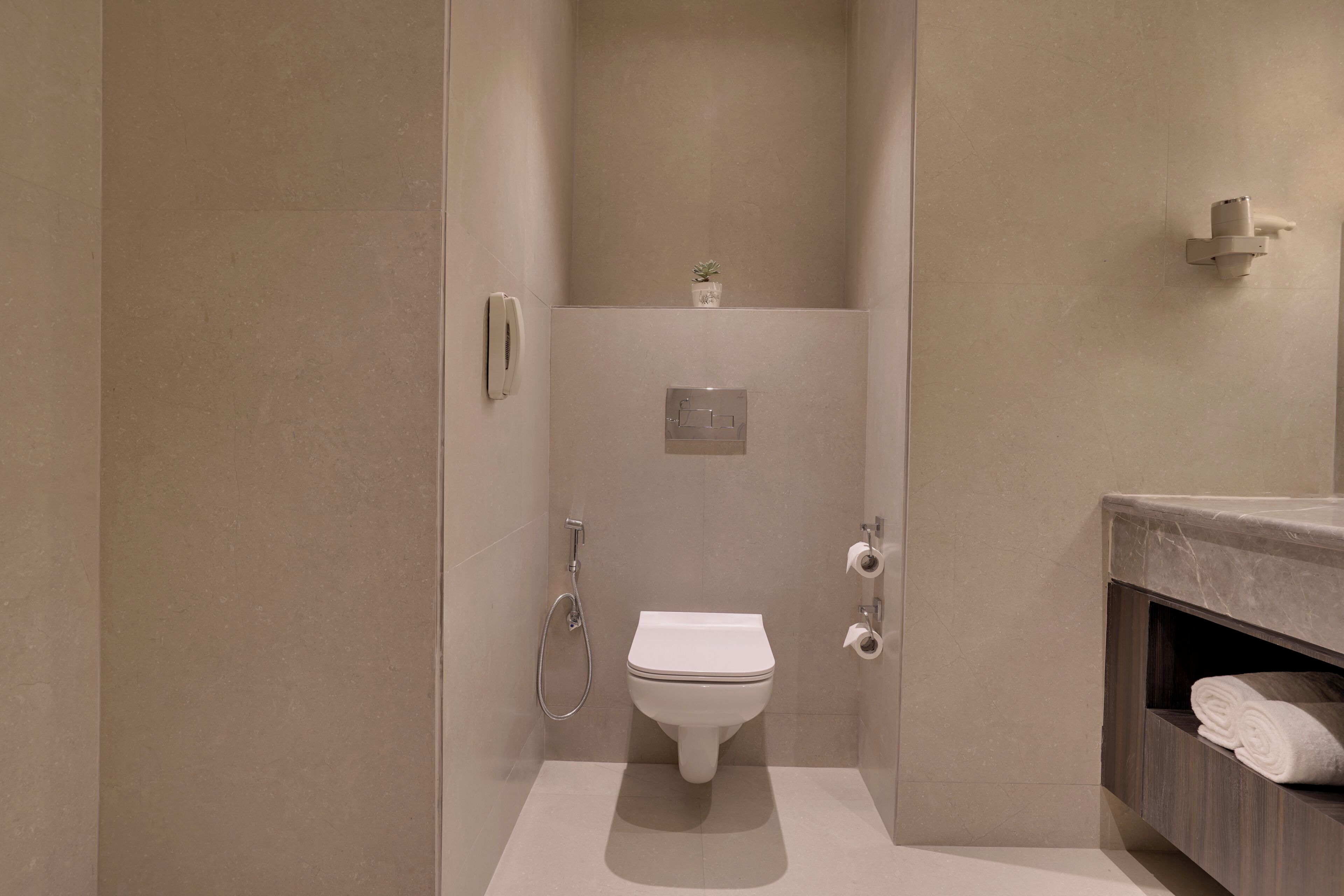 A modern bathroom with a toilet, shower, and vanity.