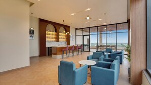 Un vestíbulo amplio con mostrador de recepción, zona de estar y ventanas grandes que ofrecen vistas.