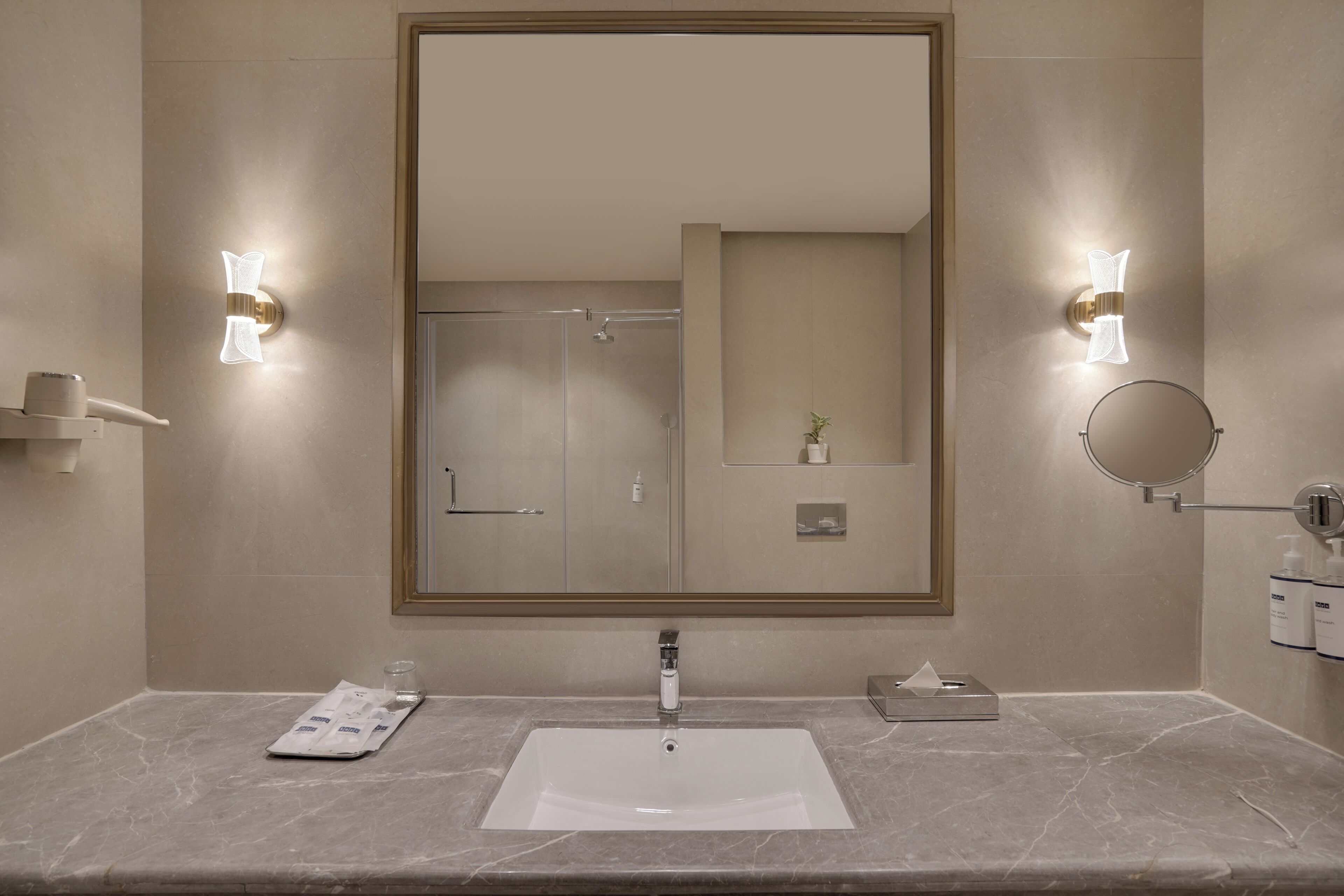 A bathroom with a large mirror, a sink, a towel, and a glass.