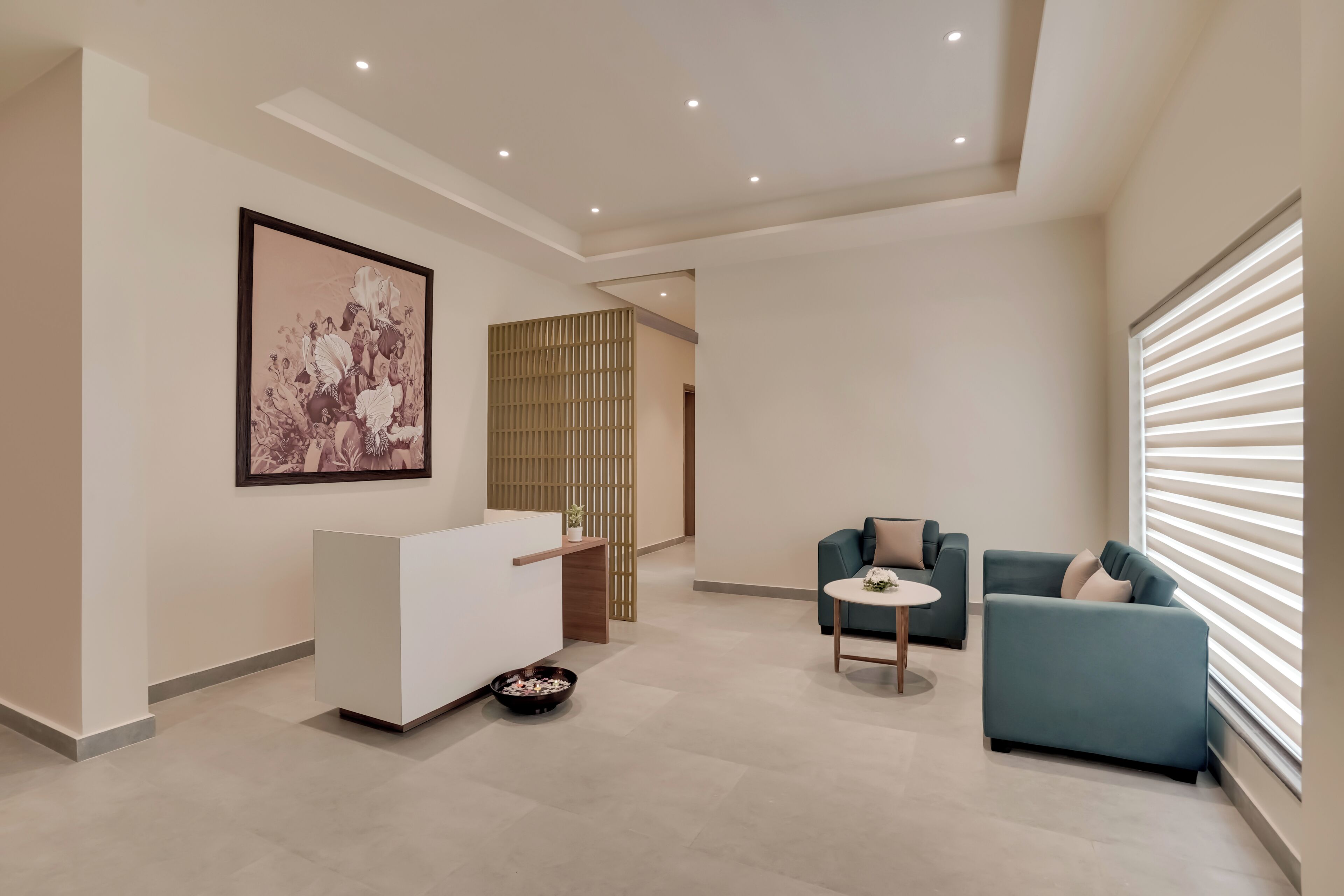 A modern interior with a reception desk, seating area, and artwork on the wall.