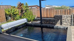 A swimming pool with a wooden deck, stone steps, and a wooden fence. - 3* family villa - Walking distance to the lagoon - Heated pool - Saint-Leu (Saint-Leu)