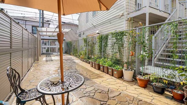 A covered outdoor area with a table and chairs, potted plants, and a staircase. -  Asagaya Room B｜1R｜10 Min to Shinjuku｜Budget Studio for 2 (Suginami City)